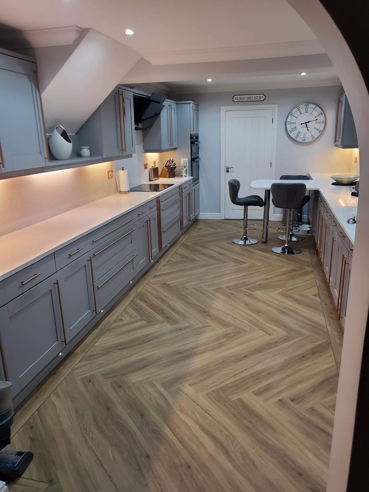 Arctic Starburst worktops down both sides of a galley kitchen, looking towards the breakfast bar