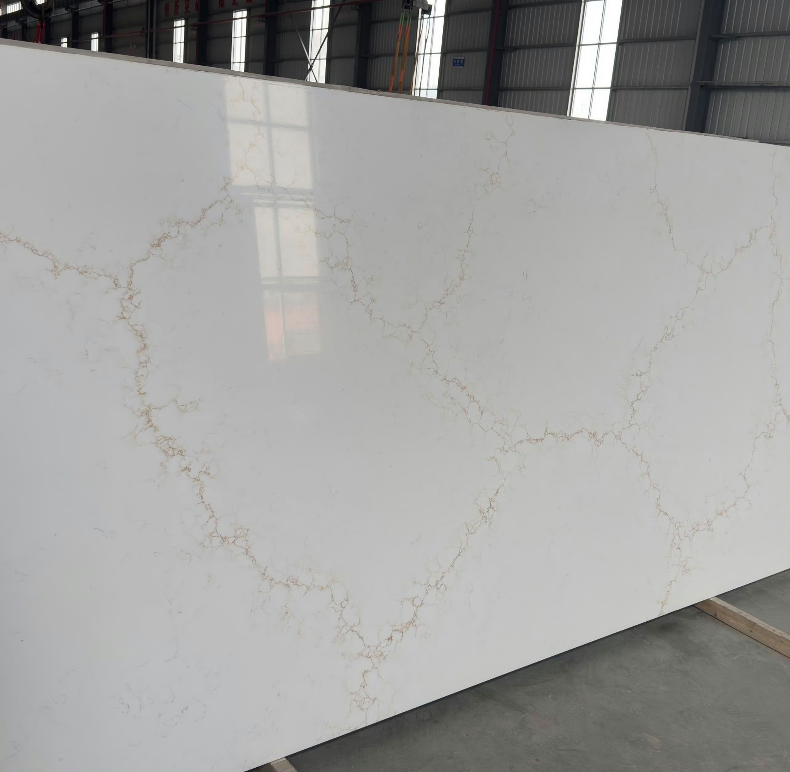 A polished Aurora Gold slab in the workshop before cutting, the gold vein running across the whole sheet