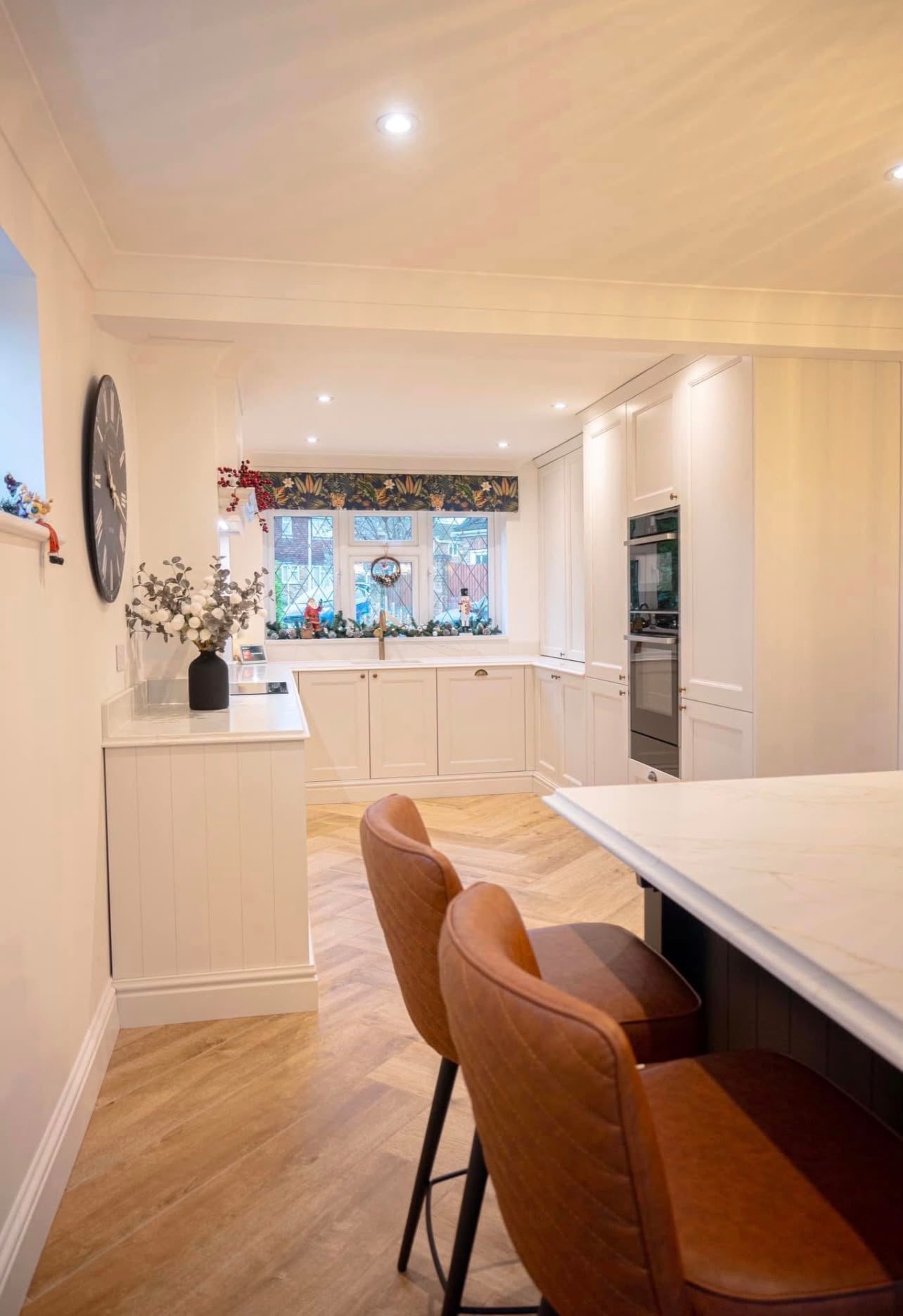 Calacatta Gold island seen down the length of an open-plan cream kitchen