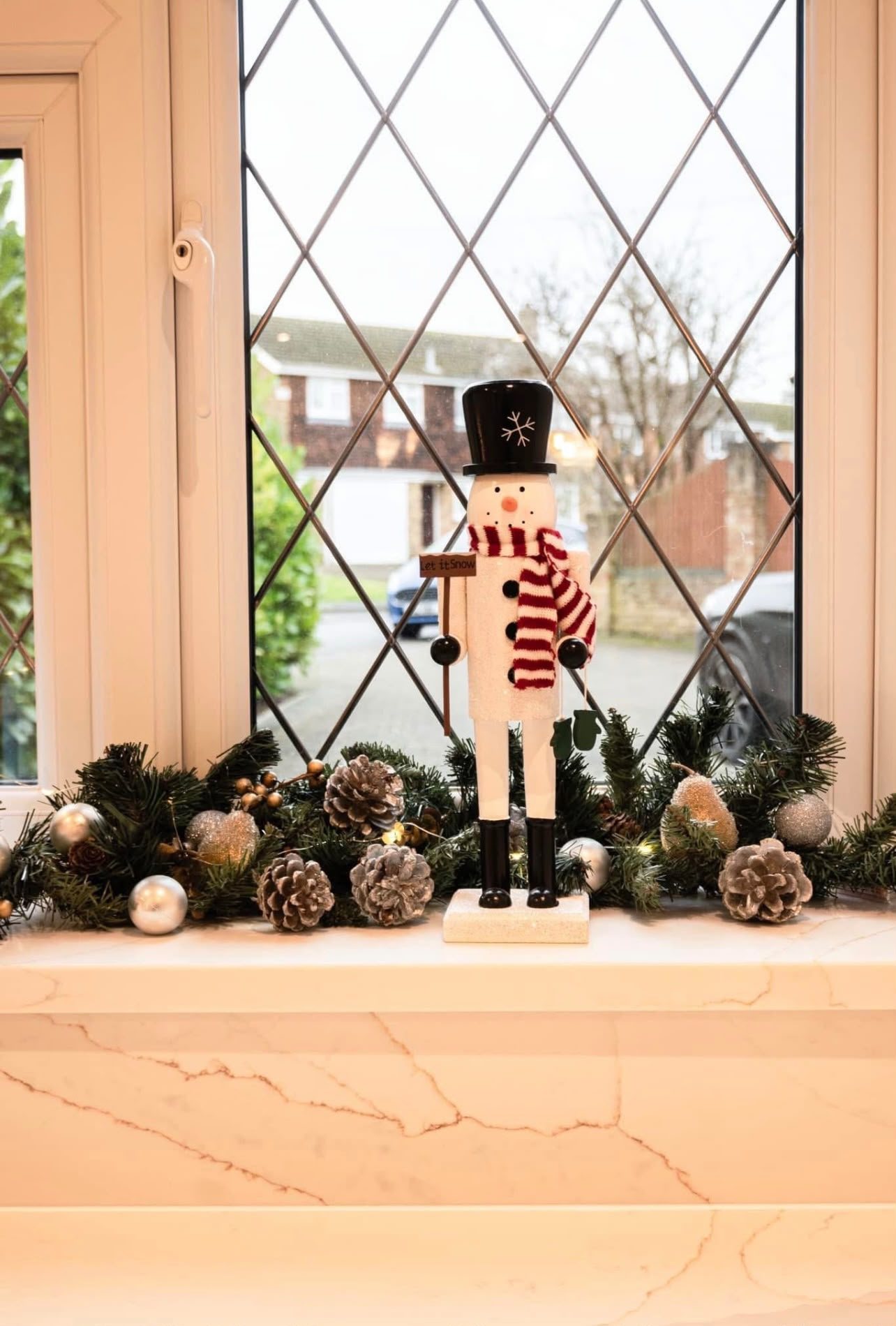 Calacatta Gold window sill with a nutcracker and pine cones set out on it