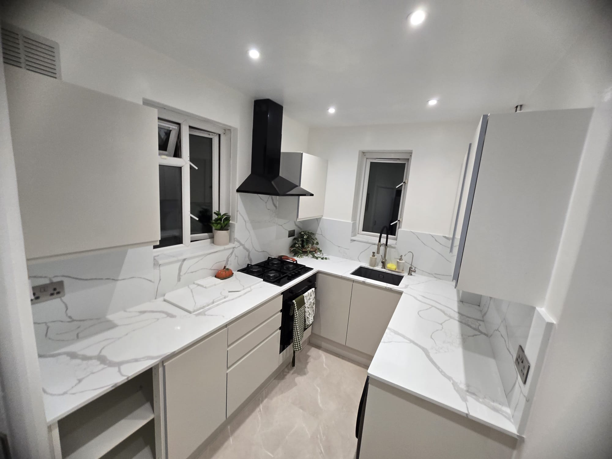 Calacatta Venato running from the hob round the corner to the sink, the grey vein carried up the splashback behind it