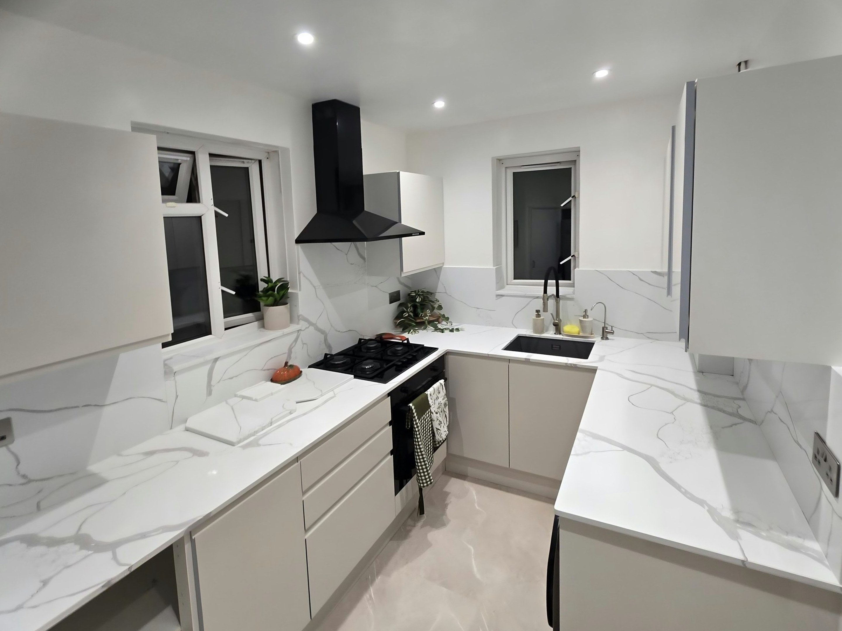 Calacatta Venato running from the hob round the corner to the sink, the grey vein carried up the splashback behind it