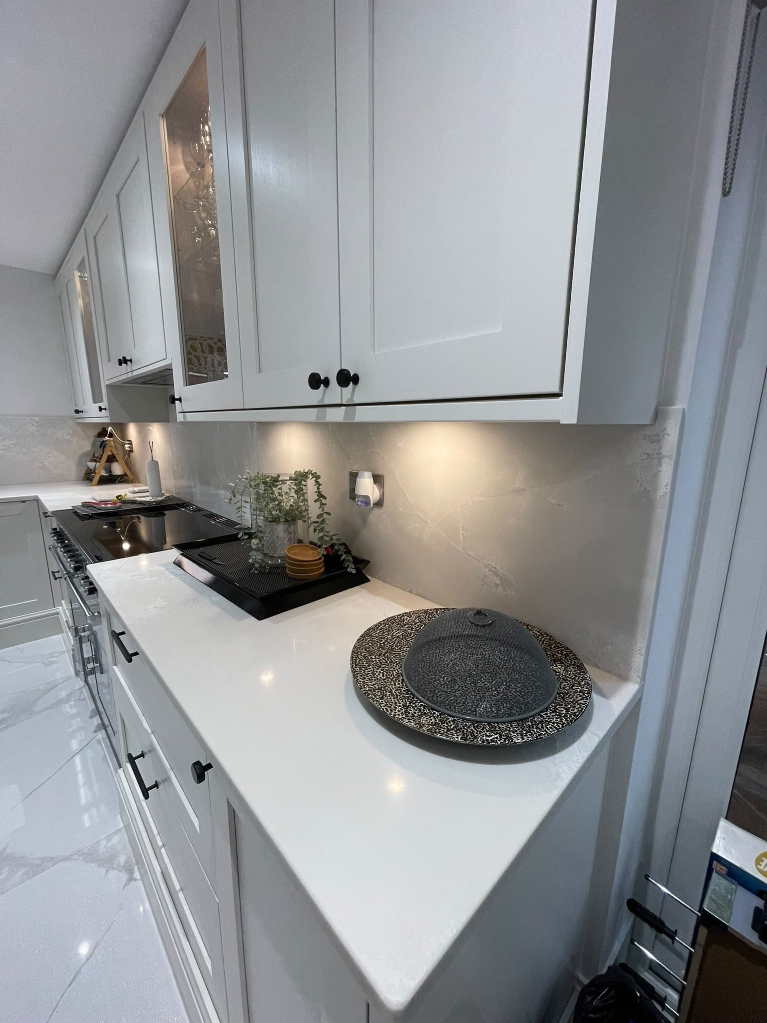 Polar White worktop beside the hob, with the tall units and cooker to the left