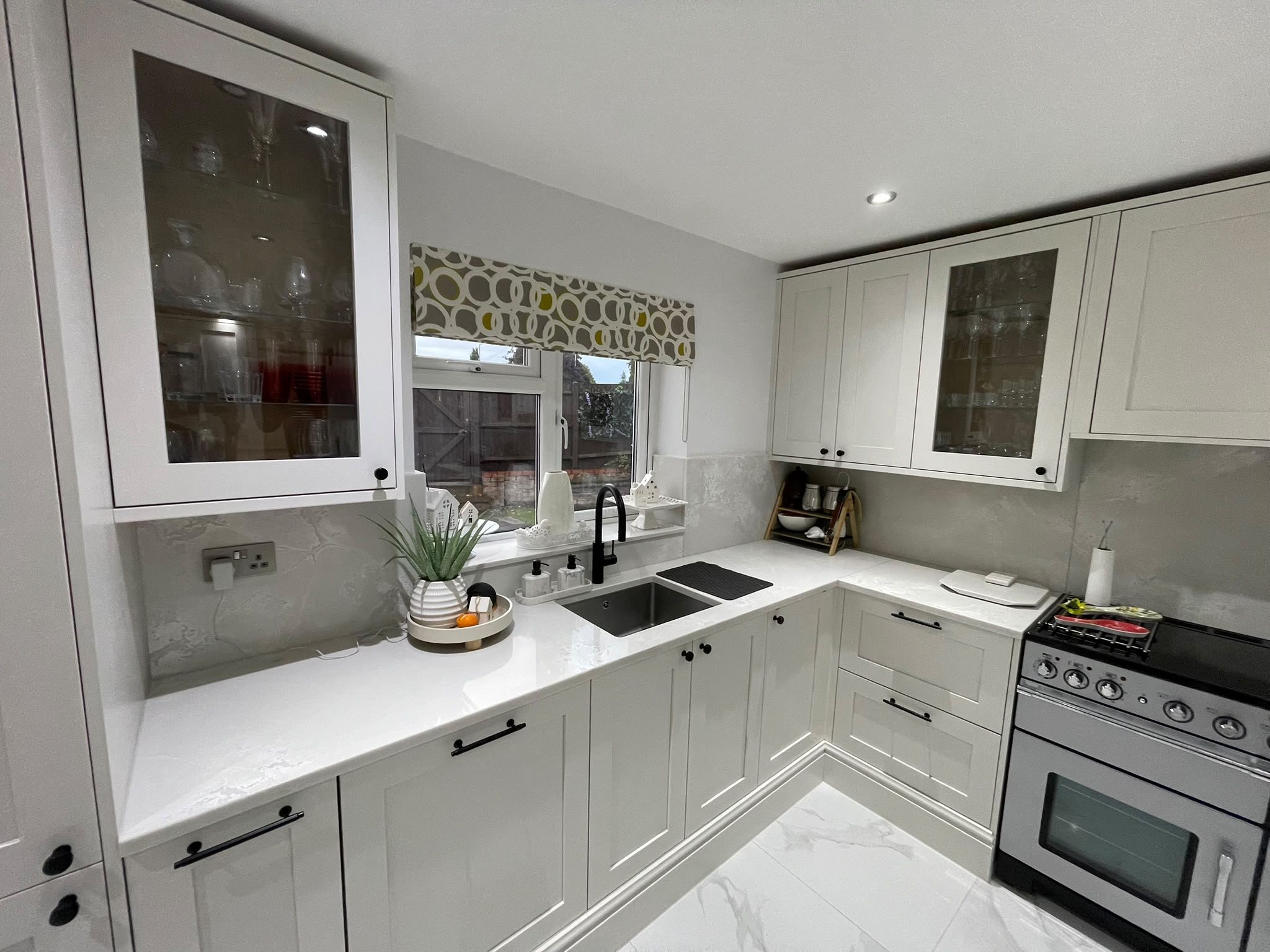 L-shaped kitchen with Polar White worktops, the sink under the window and the range cooker to the right