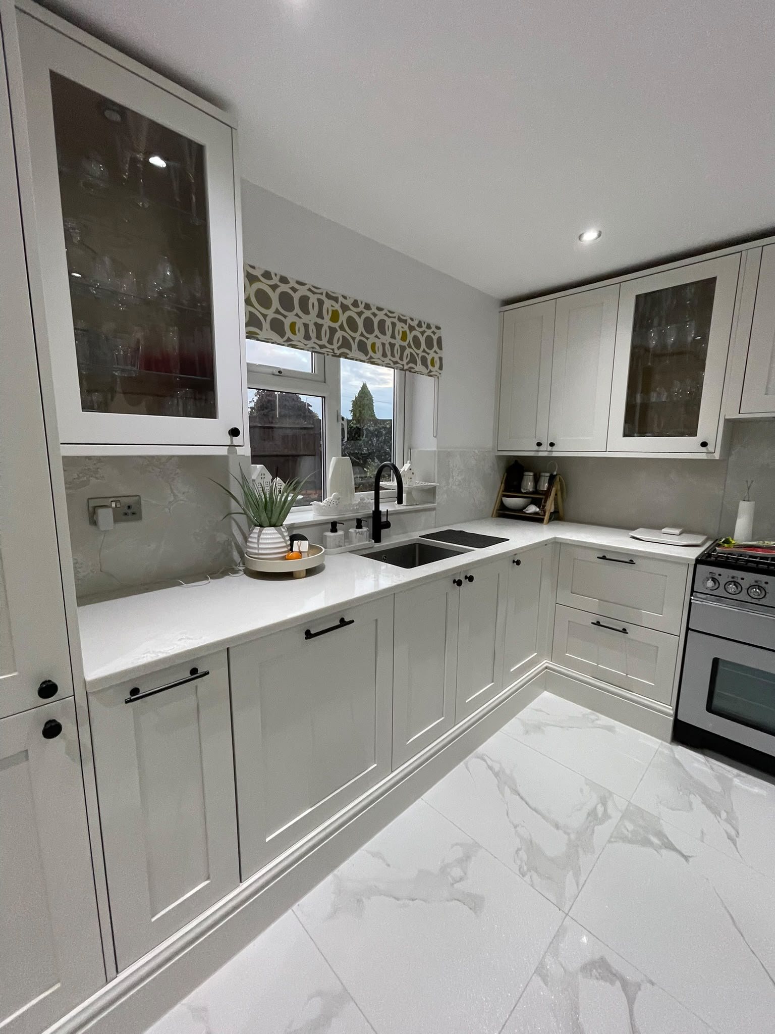 Polar White worktops around a light grey shaker kitchen, the range cooker on the right