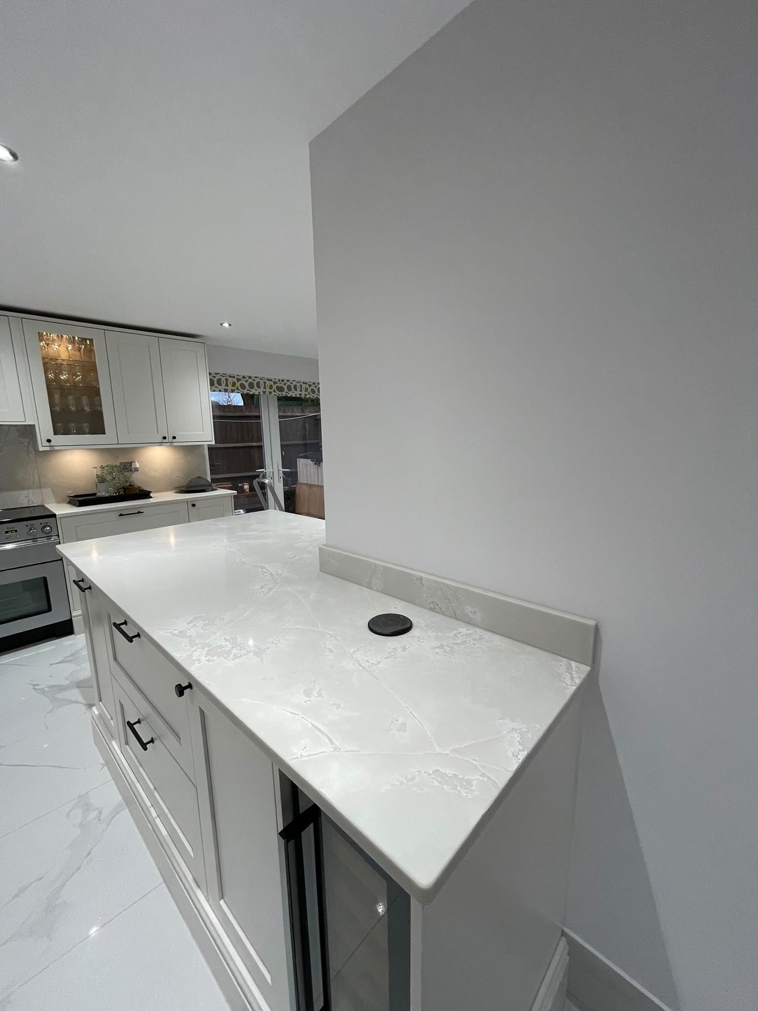 Polar White worktop turning the corner past the cooker, with the return wall behind