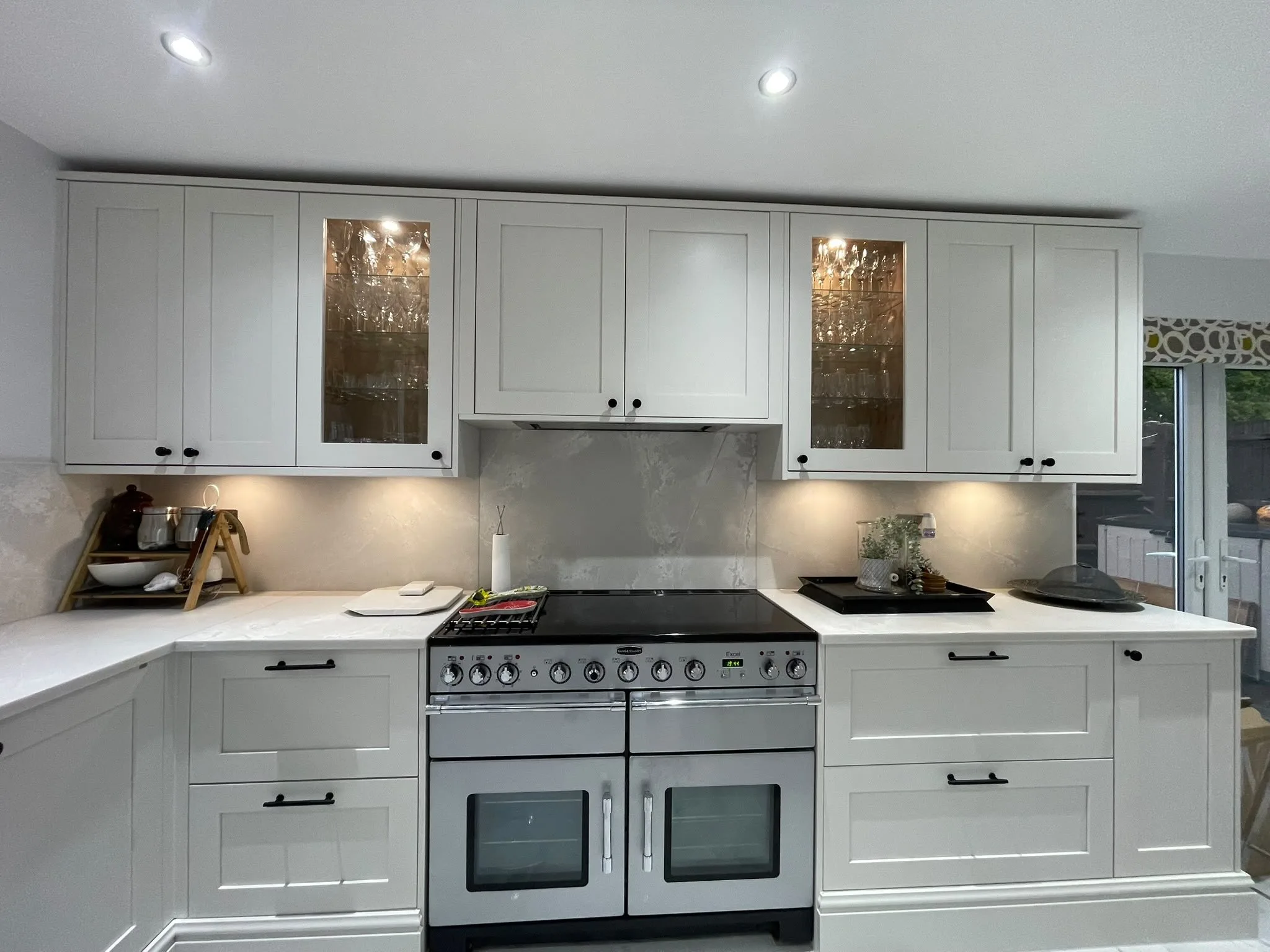 White shaker kitchen with Polar White worktops either side of a range cooker