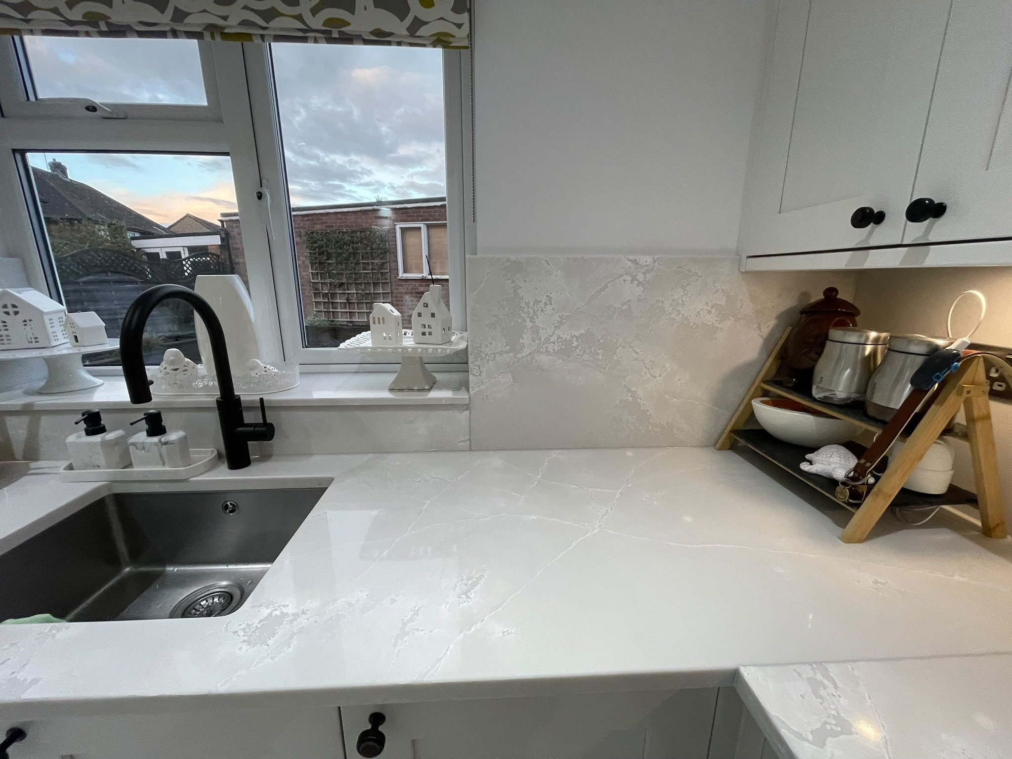 Polar White worktop running from the sink round to the corner, with a wooden drainer rack