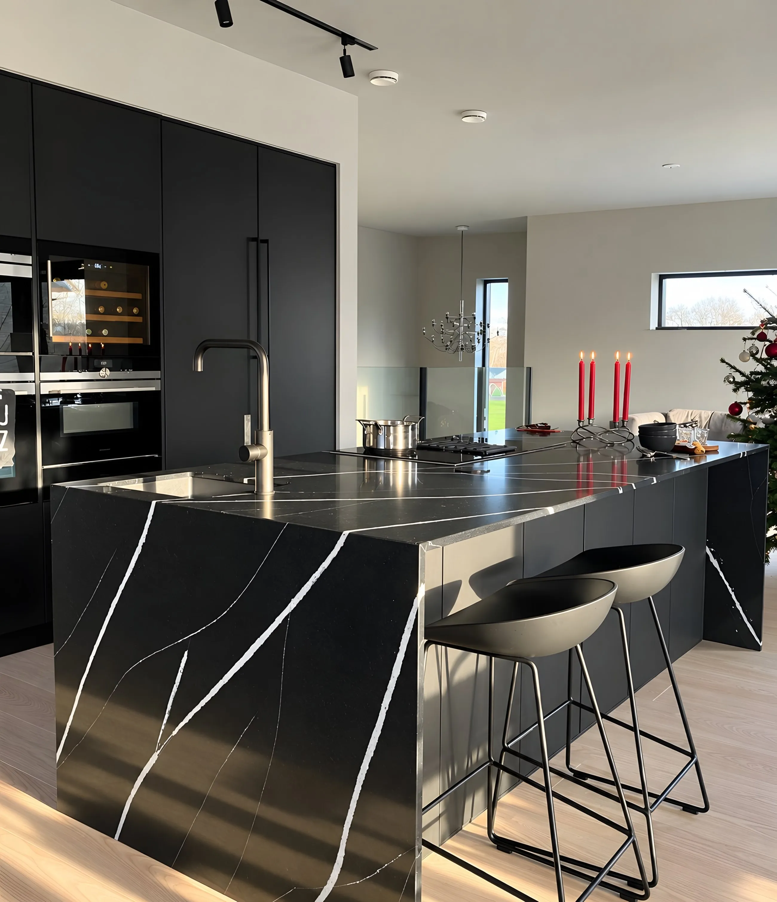 A black stone island with bold white veining and a waterfall end, with stools along one side